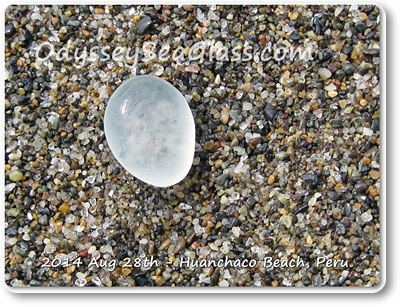 Pale blue sea glass stands out against the darker rocks