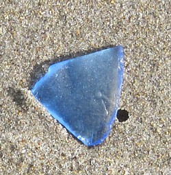 Ice blue sea glass on top of much sand newsletter