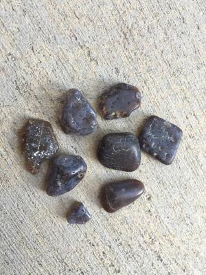 They have inclusions all through them and look black until they are held up to the light. Agates??